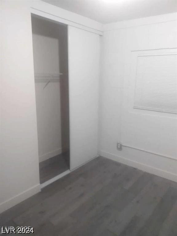 1317 Exley Ave, Las Vegas, NV 89104 - unfurnished bedroom with a closet, baseboards, and wood finished floors