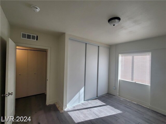 1317 Exley Ave, Las Vegas, NV 89104 - unfurnished bedroom featuring baseboards, a closet, wood finished floors, and visible vents