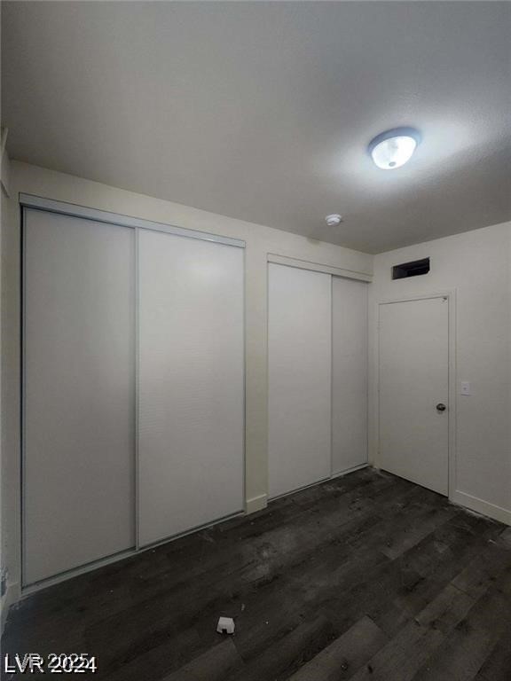 1317 Exley Ave, Las Vegas, NV 89104 - unfurnished bedroom featuring two closets and dark wood finished floors