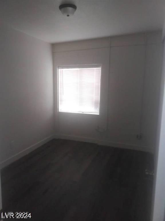 1317 Exley Ave, Las Vegas, NV 89104 - spare room featuring baseboards and dark wood-style flooring