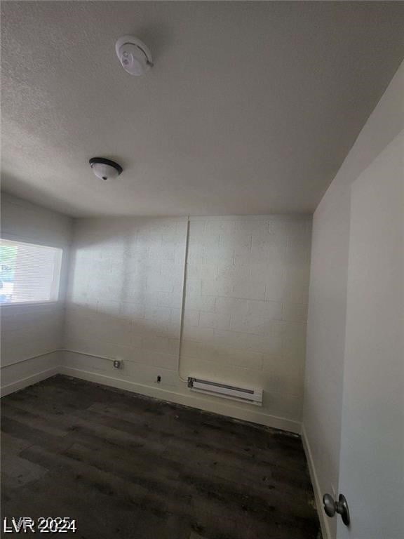 1317 Exley Ave, Las Vegas, NV 89104 - spare room featuring baseboards, dark wood finished floors, and baseboard heating