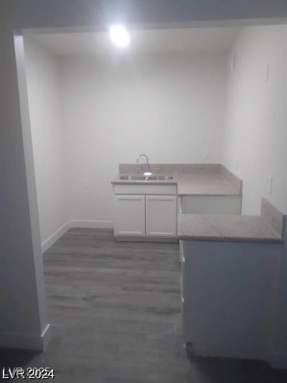 1317 Exley Ave, Las Vegas, NV 89104 - interior space with dark wood-style flooring, a sink, baseboards, white cabinets, and light countertops