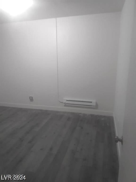 1317 Exley Ave, Las Vegas, NV 89104 - empty room featuring baseboards, a baseboard heating unit, and wood finished floors