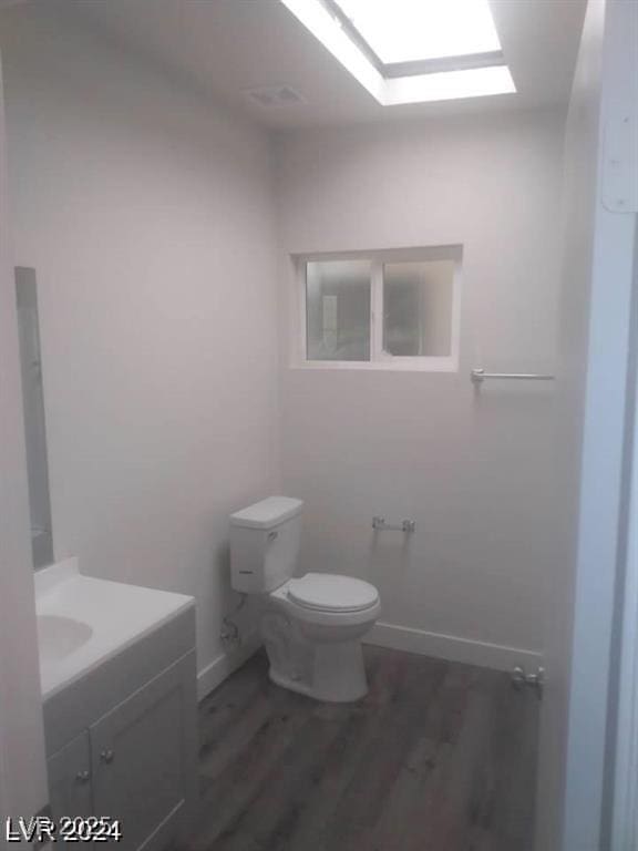 1317 Exley Ave, Las Vegas, NV 89104 - half bathroom featuring vanity, baseboards, wood finished floors, and toilet