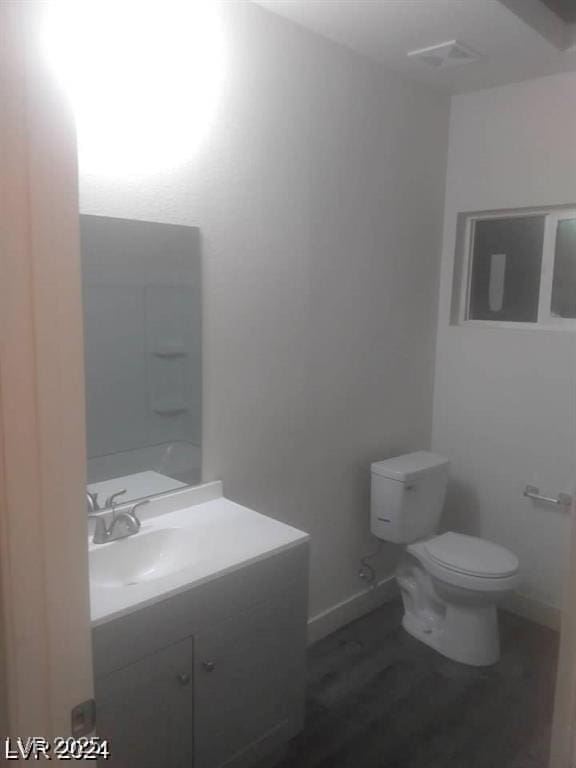 1317 Exley Ave, Las Vegas, NV 89104 - bathroom featuring toilet, baseboards, wood finished floors, and vanity