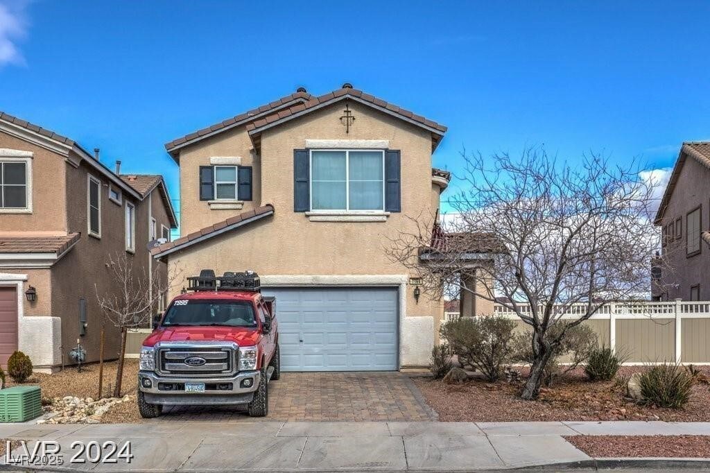 1168 Aspen Cliff Dr, Henderson, NV 89011 - traditional home featuring a tiled roof, decorative driveway, fence, an attached garage, and stucco siding
