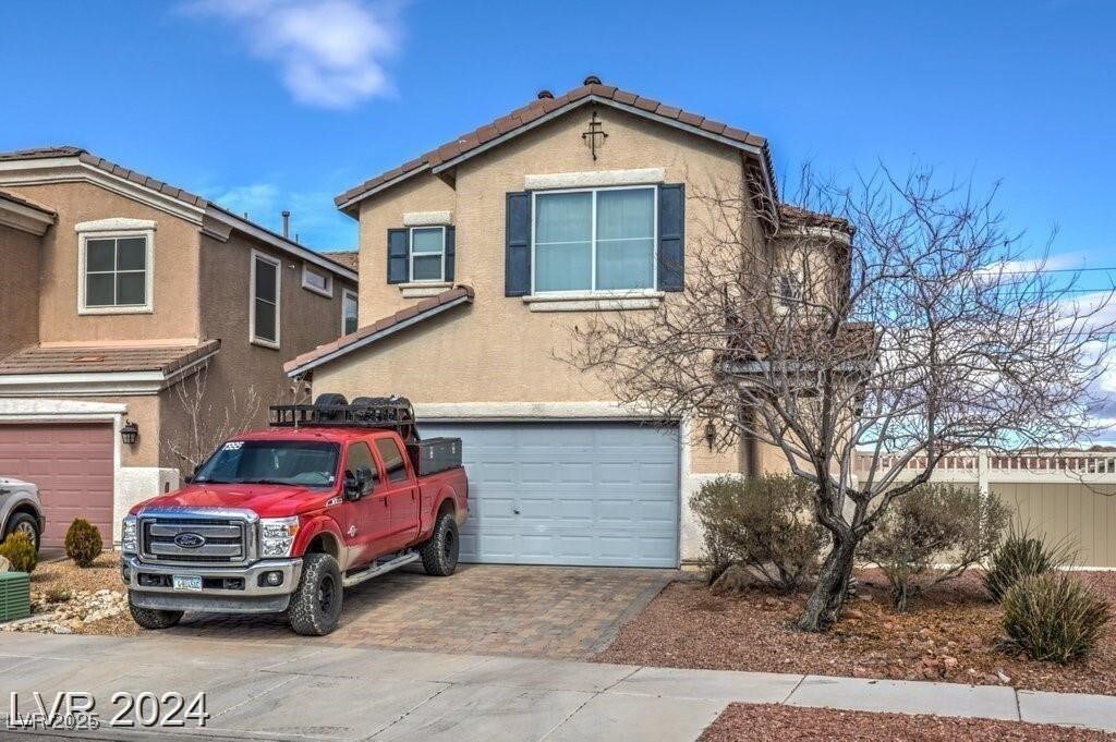 1168 Aspen Cliff Dr, Henderson, NV 89011 - view of front of home with a tiled roof, decorative driveway, a garage, and stucco siding