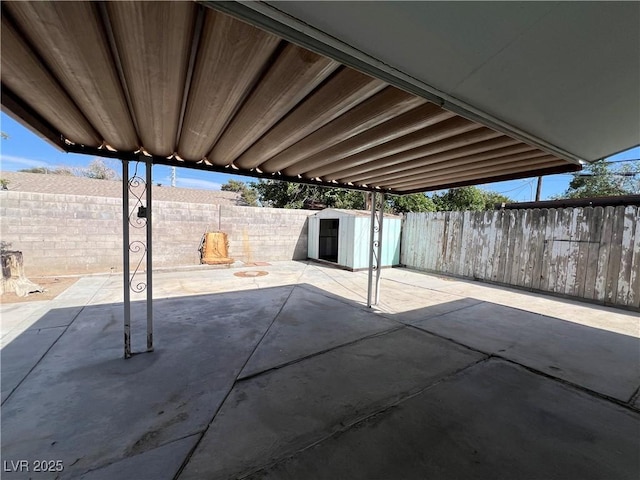 view of patio featuring a storage shed, an outbuilding, and a fenced backyard