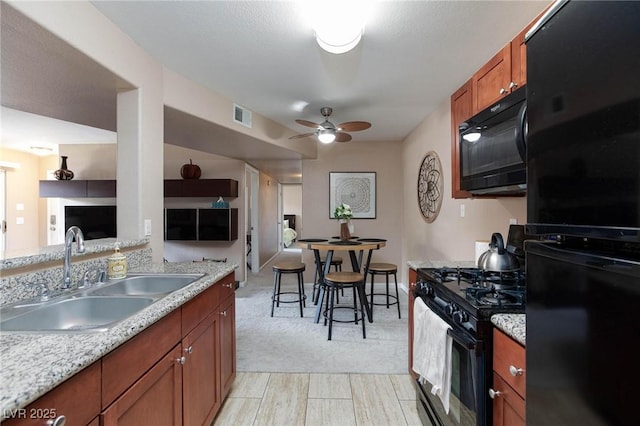 2120 Ramrod Ave Unit 513, Henderson, NV 89014 - kitchen with black appliances, a sink, ceiling fan, brown cabinetry, and light colored carpet