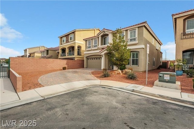 mediterranean / spanish home with stucco siding, decorative driveway, fence, and a garage