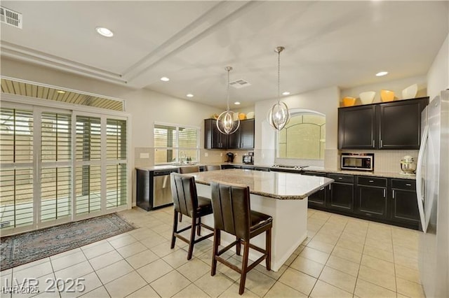 kitchen with a breakfast bar area, stainless steel appliances, visible vents, and light tile patterned floors