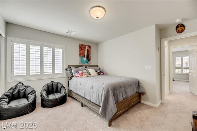 carpeted bedroom featuring baseboards and visible vents