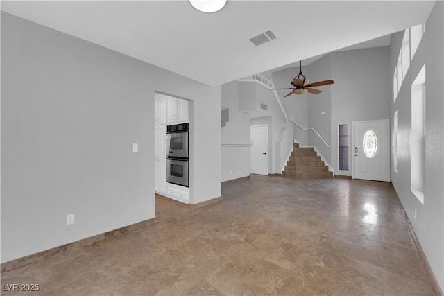 204 Appian Way, Henderson, NV 89002 - unfurnished living room with a ceiling fan, a towering ceiling, visible vents, stairway, and baseboards