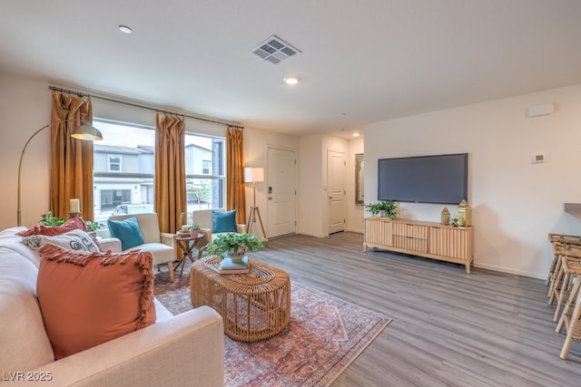 living room featuring recessed lighting, baseboards, visible vents, and wood finished floors