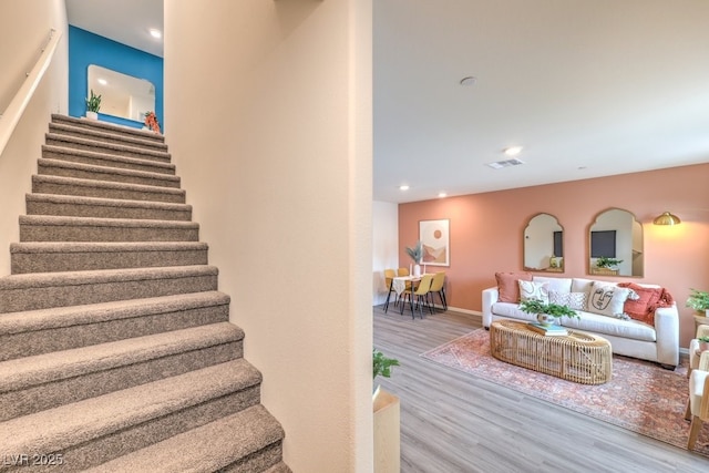 stairs with recessed lighting, visible vents, and wood finished floors
