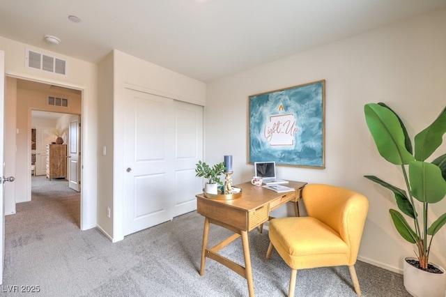 office space featuring baseboards, visible vents, and light colored carpet