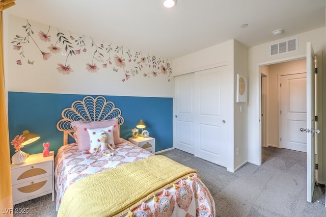carpeted bedroom featuring baseboards, visible vents, and a closet