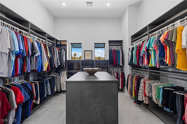 walk in closet with a high ceiling, visible vents, and tile patterned floors