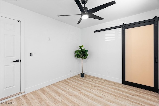 1020 Baker Ave, Las Vegas, NV 89108 - empty room with baseboards, ceiling fan, light wood-style flooring, and a barn door