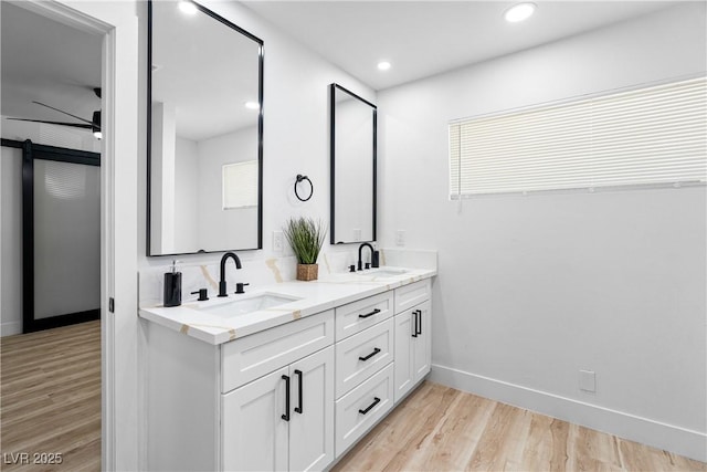 1020 Baker Ave, Las Vegas, NV 89108 - full bathroom featuring baseboards, a sink, wood finished floors, and double vanity