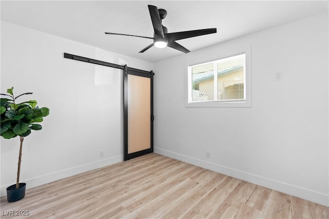 1020 Baker Ave, Las Vegas, NV 89108 - unfurnished bedroom with light wood-style floors, a barn door, baseboards, and a ceiling fan