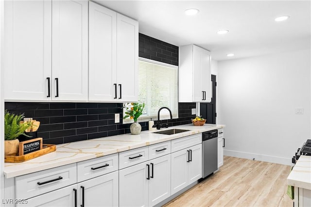 1020 Baker Ave, Las Vegas, NV 89108 - kitchen featuring tasteful backsplash, dishwasher, a sink, baseboards, and light wood finished floors