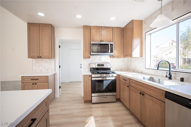 kitchen with a sink, backsplash, a healthy amount of sunlight, and stainless steel appliances