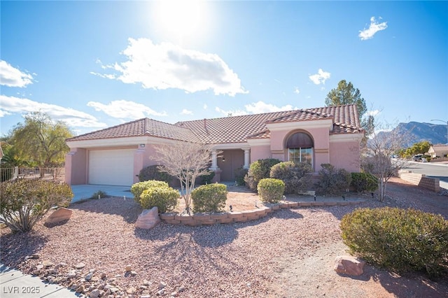 mediterranean / spanish house featuring a garage, fence, stucco siding, concrete driveway, and a tile roof