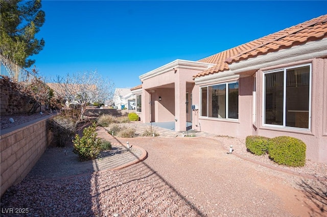 back of property featuring a patio area, stucco siding, and a tile roof