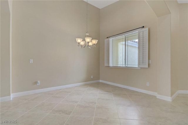 empty room with baseboards, a towering ceiling, light tile patterned floors, and a chandelier