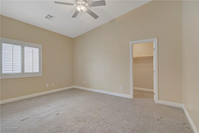 unfurnished bedroom with visible vents, carpet, a walk in closet, and baseboards