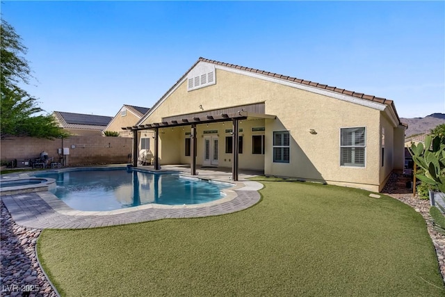 rear view of property featuring a pool with connected hot tub, stucco siding, a fenced backyard, a patio area, and french doors