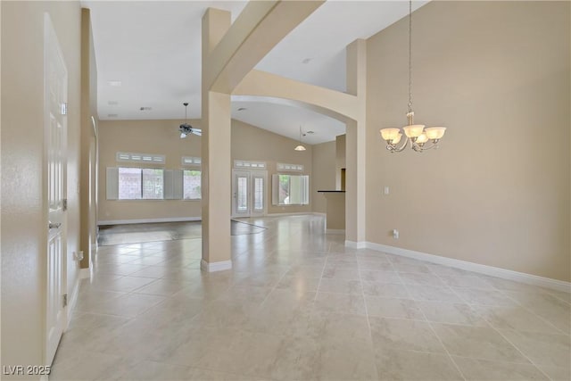 empty room with arched walkways, high vaulted ceiling, baseboards, and ceiling fan with notable chandelier