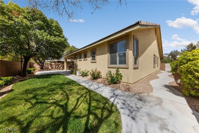 4217 Box Canyon Falls Ave, North Las Vegas, NV 89085 - view of home's exterior with a lawn, stucco siding, and fence