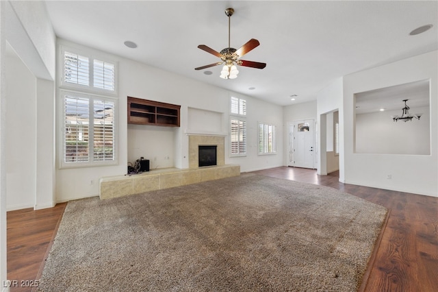 4217 Box Canyon Falls Ave, North Las Vegas, NV 89085 - unfurnished living room with baseboards, ceiling fan, a tiled fireplace, and wood finished floors