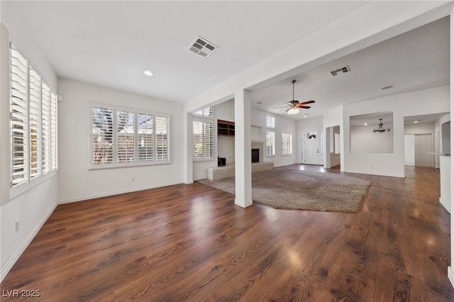 4217 Box Canyon Falls Ave, North Las Vegas, NV 89085 - unfurnished living room featuring a fireplace with raised hearth, visible vents, a wealth of natural light, and wood finished floors