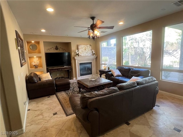 living area with baseboards, visible vents, and plenty of natural light