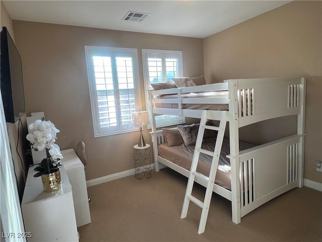 carpeted bedroom featuring visible vents and baseboards