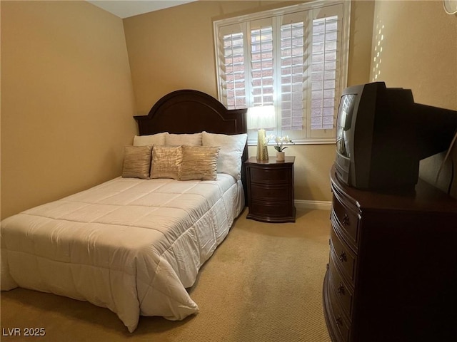 bedroom with baseboards and light colored carpet