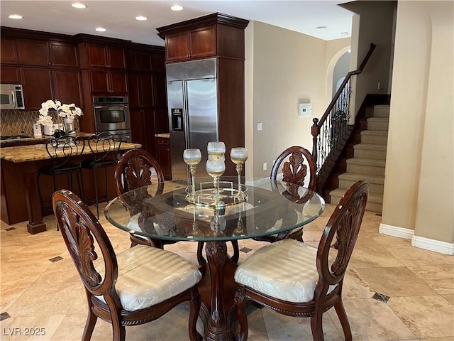 dining area featuring baseboards, recessed lighting, and stairs