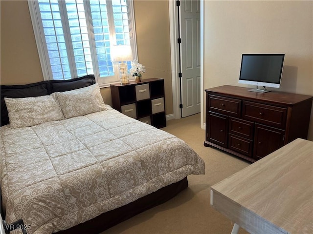 bedroom featuring baseboards and light carpet