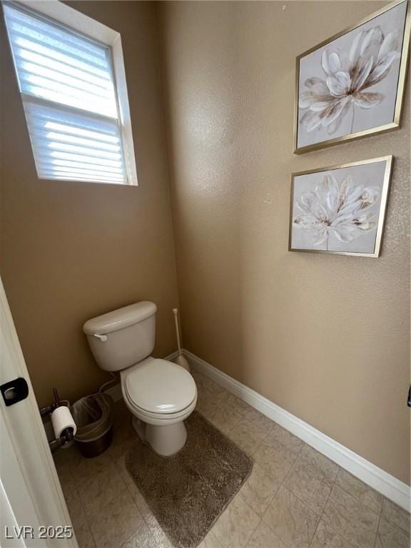 bathroom with baseboards and toilet