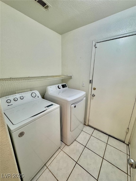 10025 Catseye Cove Ct, Las Vegas, NV 89183 - laundry room with visible vents, laundry area, a textured ceiling, washing machine and clothes dryer, and light tile patterned floors