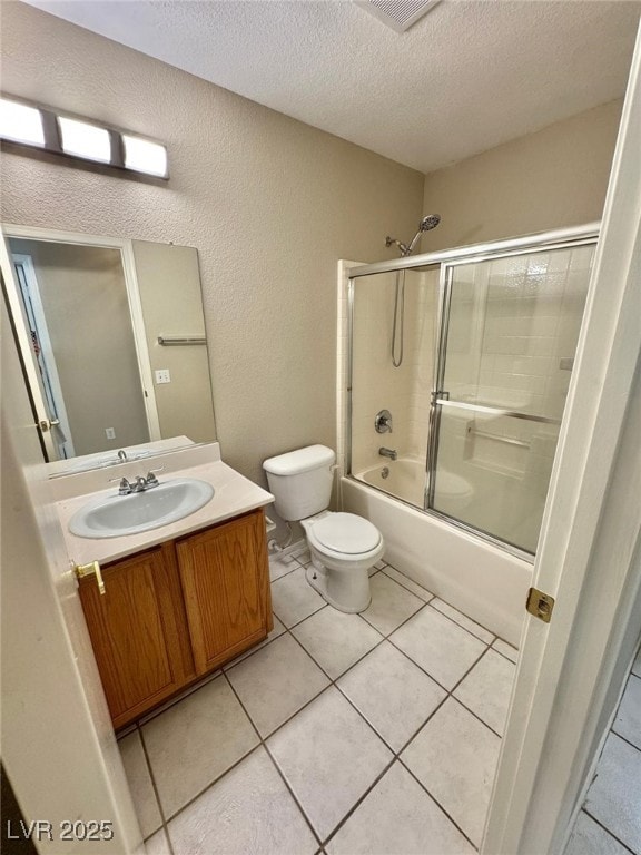 10025 Catseye Cove Ct, Las Vegas, NV 89183 - bathroom with vanity, toilet, a textured ceiling, tile patterned floors, and enclosed tub / shower combo