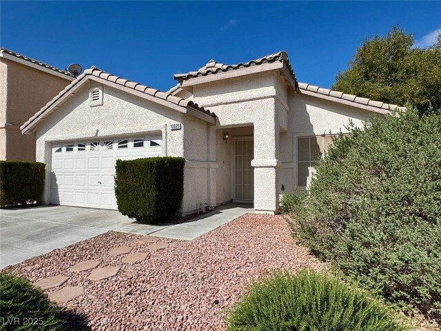 10025 Catseye Cove Ct, Las Vegas, NV 89183 - view of front facade with stucco siding, a tiled roof, concrete driveway, and a garage