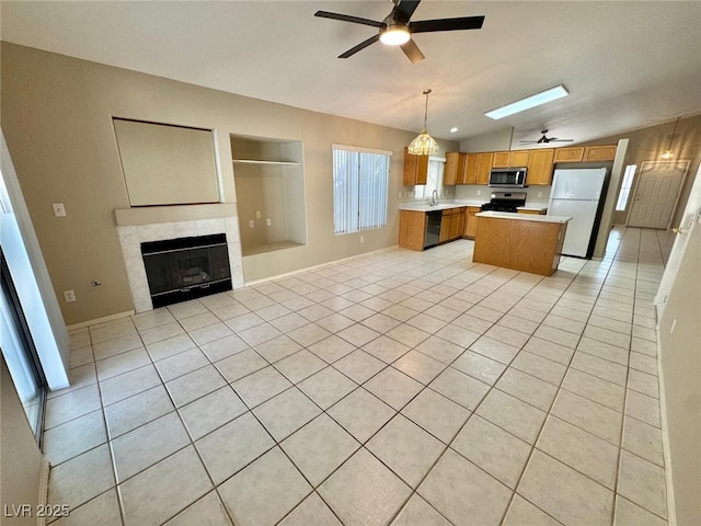 10025 Catseye Cove Ct, Las Vegas, NV 89183 - kitchen featuring open floor plan, lofted ceiling with skylight, ceiling fan, light countertops, and stainless steel appliances