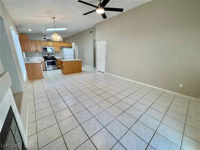 10025 Catseye Cove Ct, Las Vegas, NV 89183 - kitchen with ceiling fan, light countertops, open floor plan, stainless steel appliances, and light tile patterned flooring