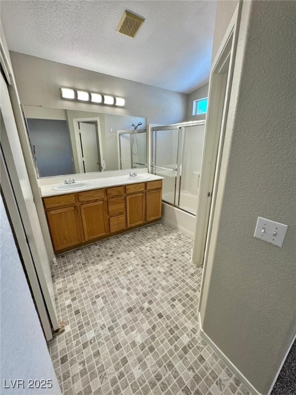 10025 Catseye Cove Ct, Las Vegas, NV 89183 - full bathroom with double vanity, visible vents, a sink, and bath / shower combo with glass door