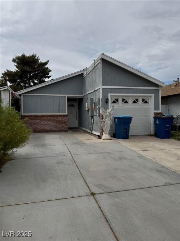 view of side of home featuring a garage and concrete driveway