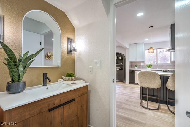 10009 Coral Sands Dr, Las Vegas, NV 89117 - bathroom with decorative backsplash, wood finished floors, vanity, a textured wall, and recessed lighting